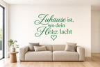 Wandtattoo „Zuhause ist, wo dein Herz lacht“ in Grün an der Wand
