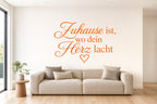 Wandtattoo „Zuhause ist, wo dein Herz lacht“ in Orange an der Wand